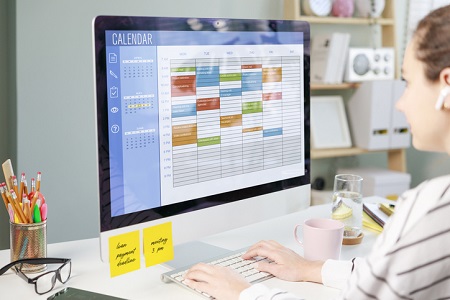 Businesswoman using a calendar on a computer to improve time management. Credit: https://www.istockphoto.com/portfolio/eternalcreative