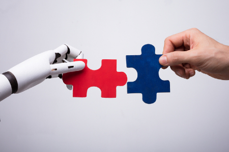 Robot hand and human hand putting puzzle pieces together. Credit: https://www.istockphoto.com/portfolio/AndreyPopov