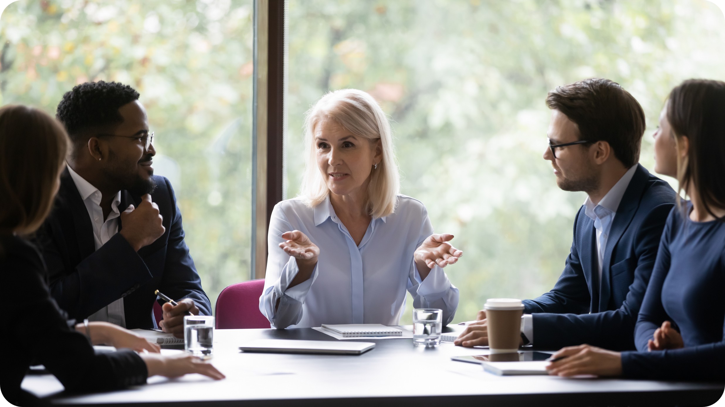 A mature aged woman CEO asking a question of her leadership team. CREDIT: https://www.istockphoto.com/portfolio/fizkes